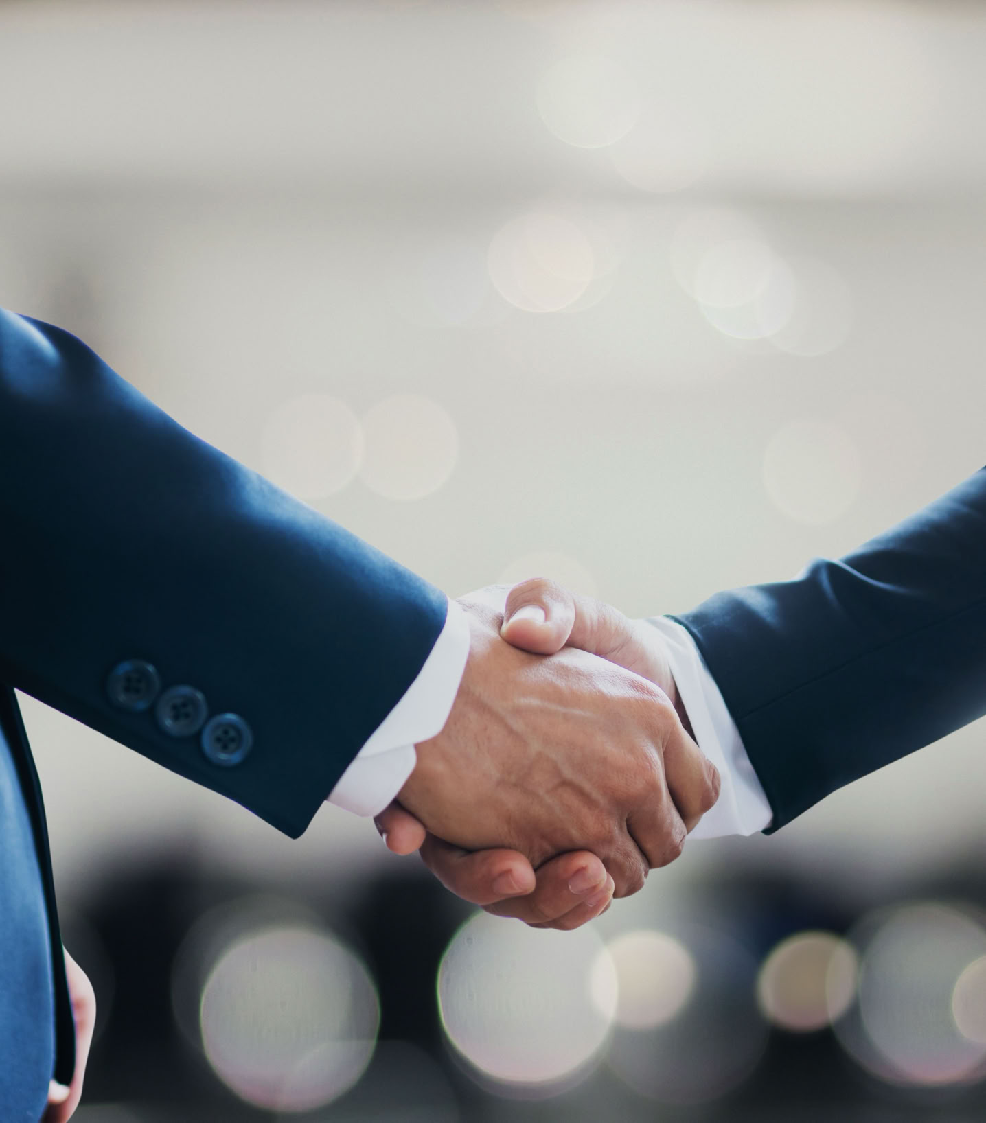 Two diverse hands shaking towards a successful business deal on a green background.