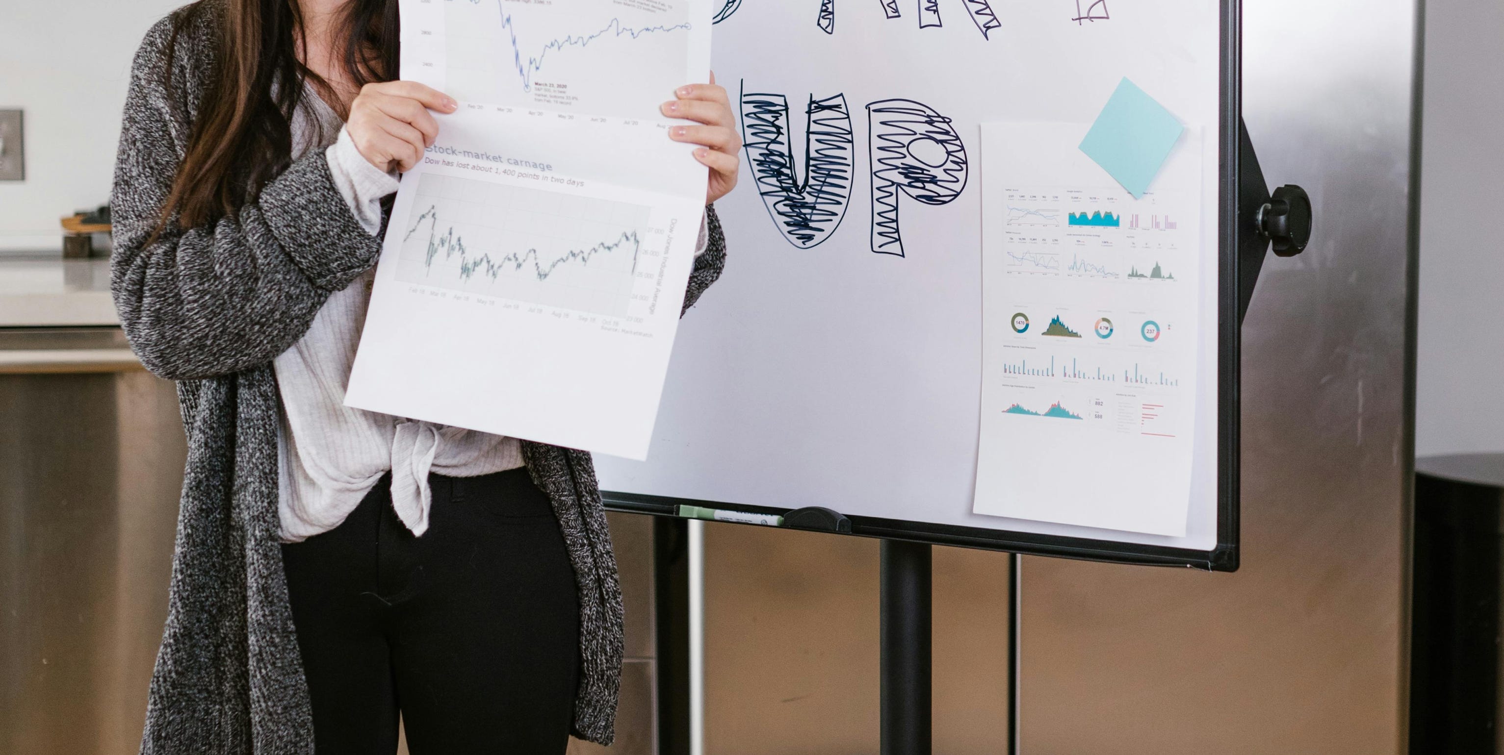 Woman in Gray Coat Holding White Printer Paper