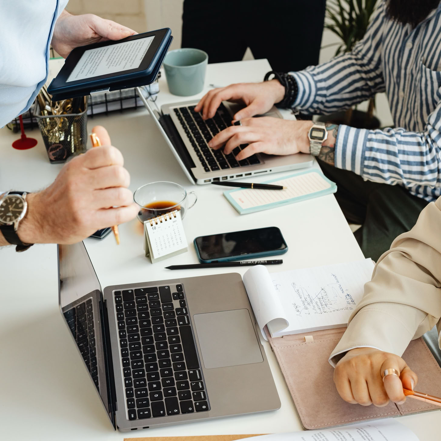 Teamwork in action with technology, papers, and collaboration at a dynamic office desk.